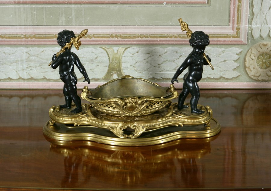 Importante centrotavola in bronzo dorato e patinato, al centro un cesto sorretto da due putti (Scultore Francese Del XIX Secolo )