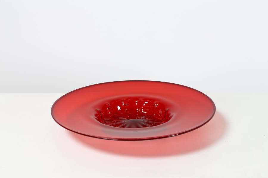 Piatto in vetro trasparente rosso rubino con fondo baccellato ottenuto con  costolatura a stampo, produzione Venini.