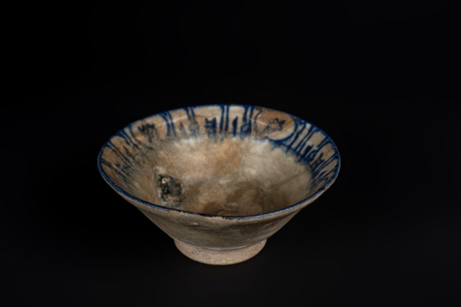A pottery bowl with blue pseudo calligraphy along the edge
Iran, Kashan, 12th-13th century  (Arte Islamica )