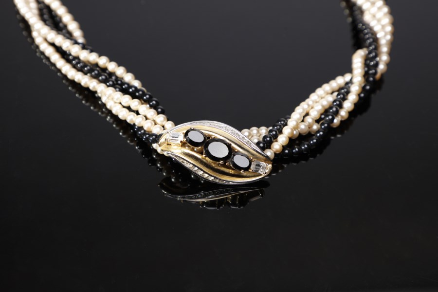 Collier torchon con fili di perle artificiali colorate bianche e nere. Fibbia a forma di foglia stilizzata con strass bianchi e neri. (Pierre  Cardin)