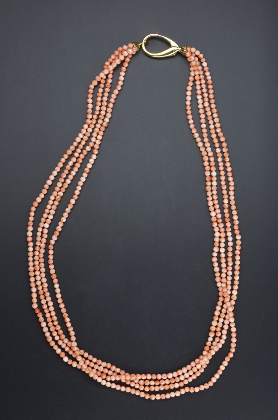 Collana di corallo rosa composta da n. 4 fili  con chiusura a moschettone in oro giallo 750-1000. Peso lordo gr 94,40. (. )