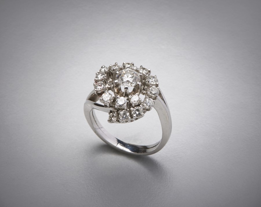 Anello in platino anni 40 con diamante centrale bianco taglio a brillante carati 0,70 circa e contorno di diamanti tondi.totale ct 1,50 circa.  (. )