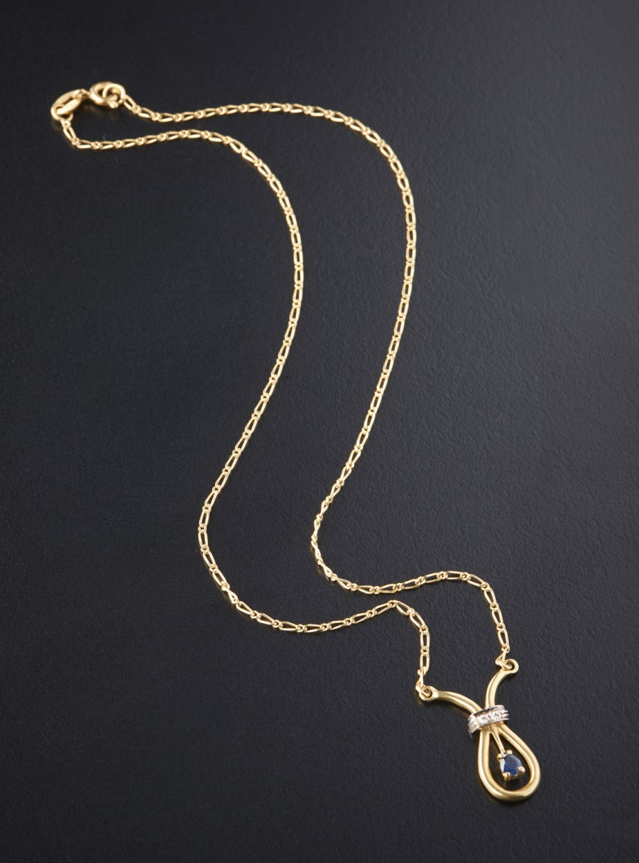 Catenina in oro giallo con zaffiro a goccia carati: 0,20 e due diamanti bianchi taglio huit huit. (. )