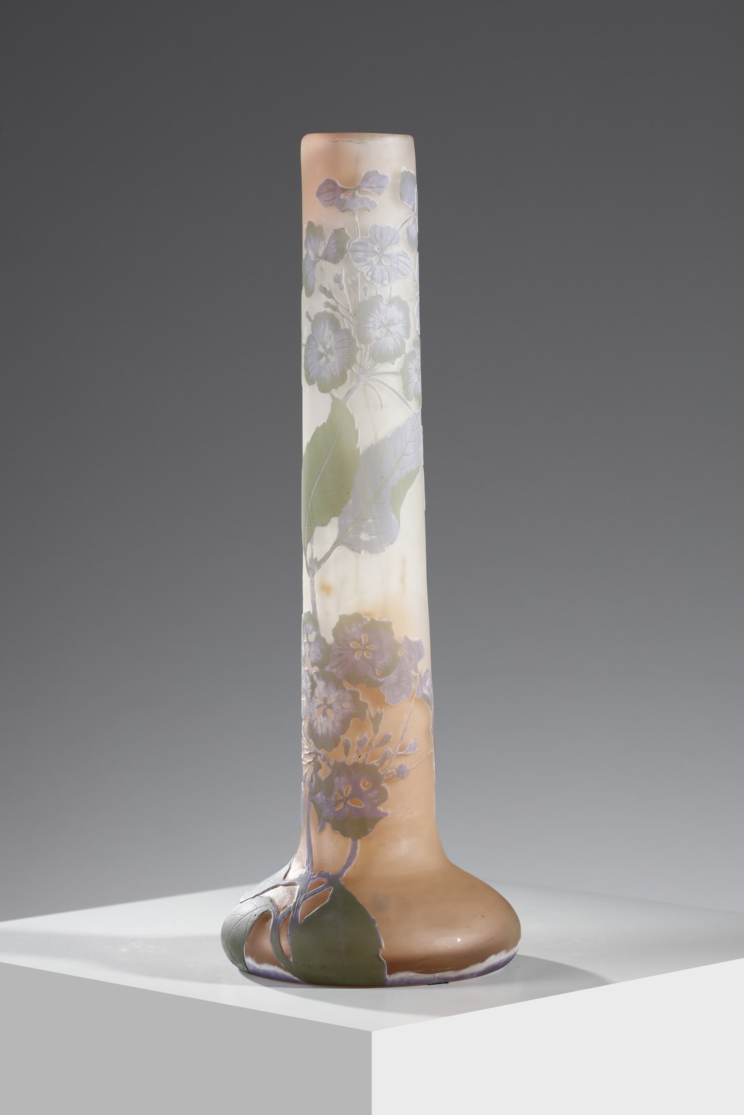 Vaso cilindrico con base a bulbo in vetro doppio, decoro di foglie e fiori nei toni del verde e del lilla, finemente inciso ad acido su fondo rosato ( Gallé)