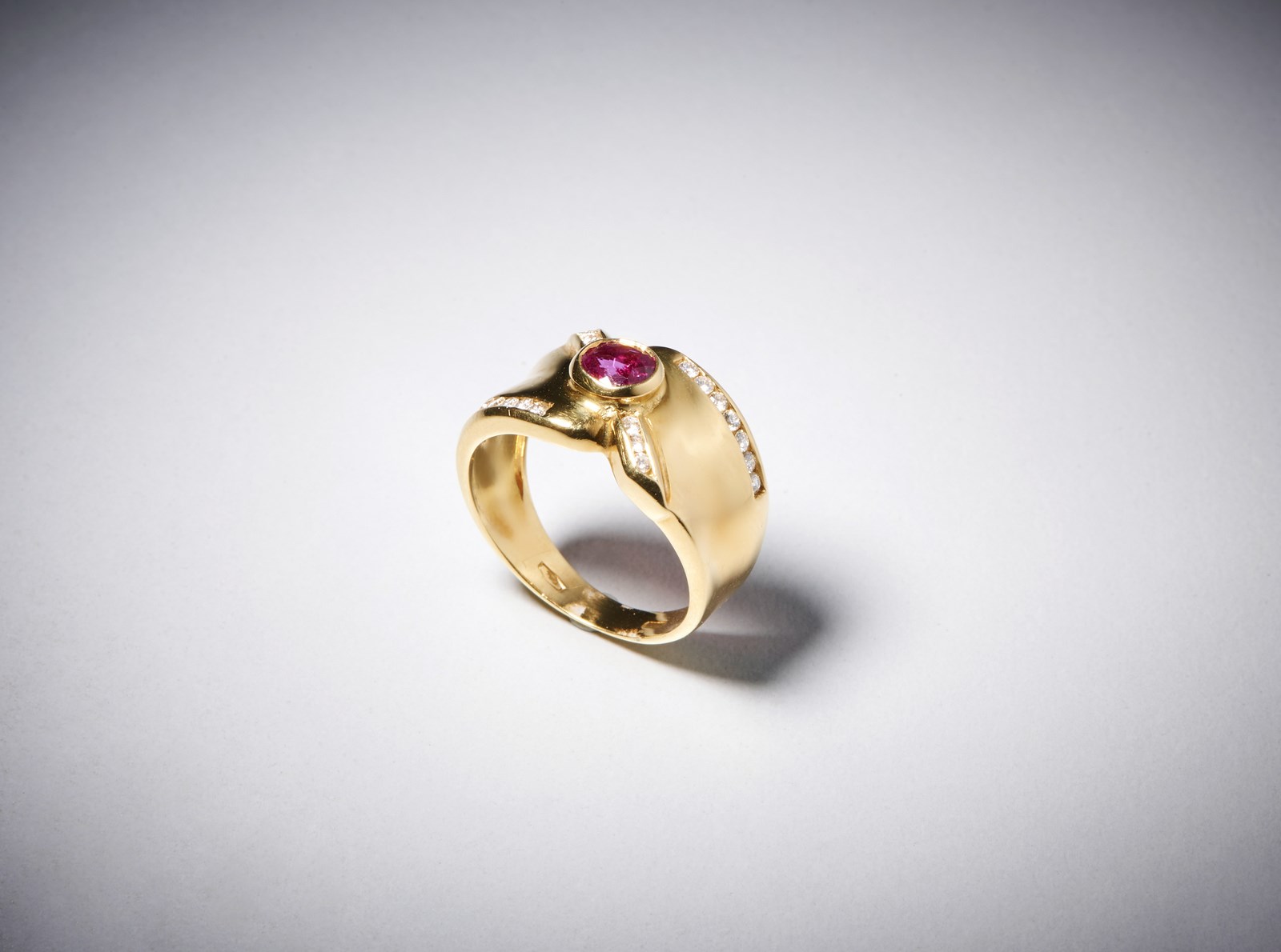 Ring to "band" in yellow gold 750/1000 with oval central ruby of approximately 0,35 ct. with outline of white diamonds brilliant cut of approximately 0,40 ct. (. )