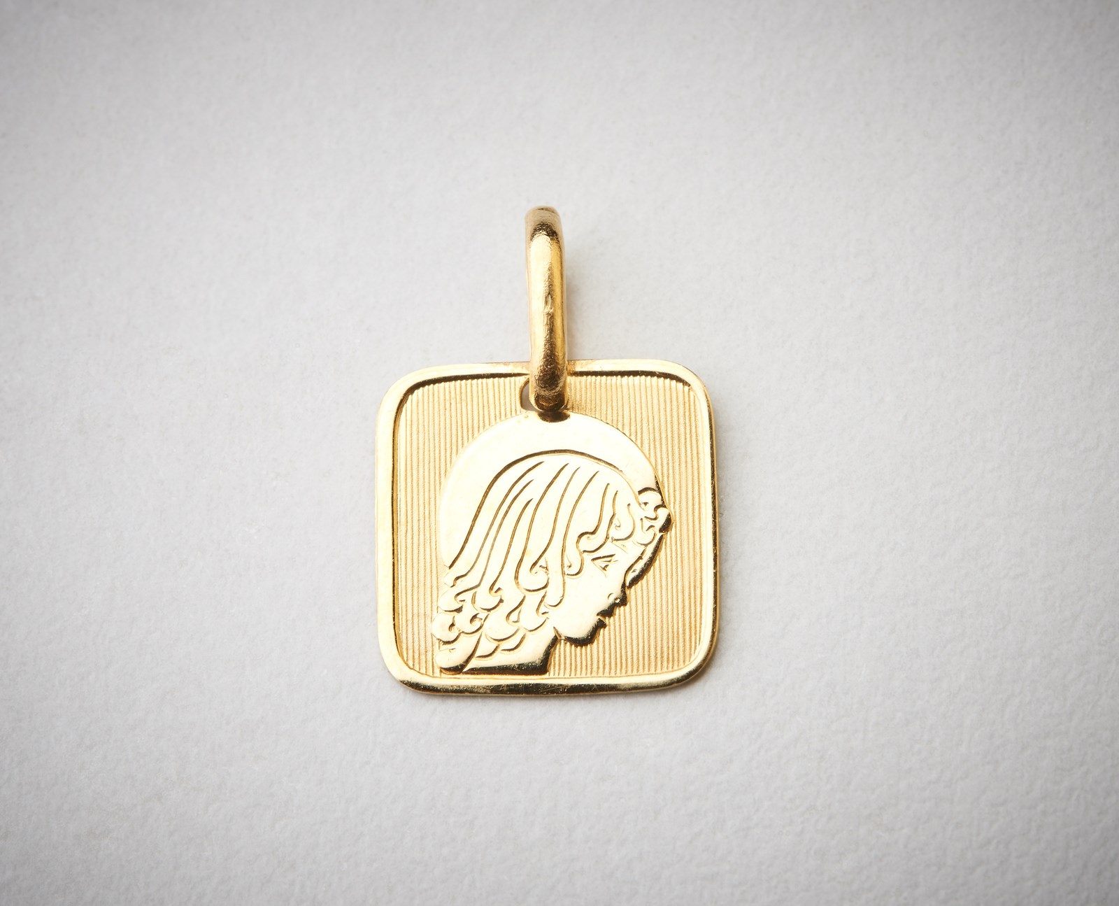 Square medal with female face yellow gold 750/1000. (. )