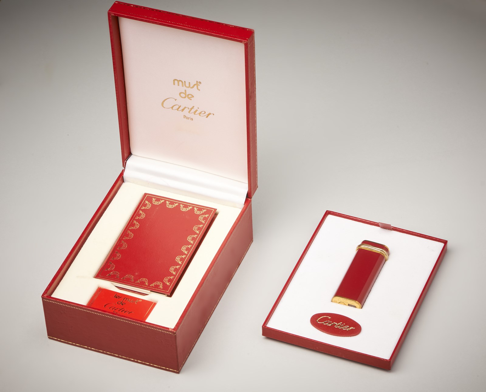 Accendino placcato  in oro 750/1000 collezione Must de Cartier con smalto di colore rosso. ( Cartier)