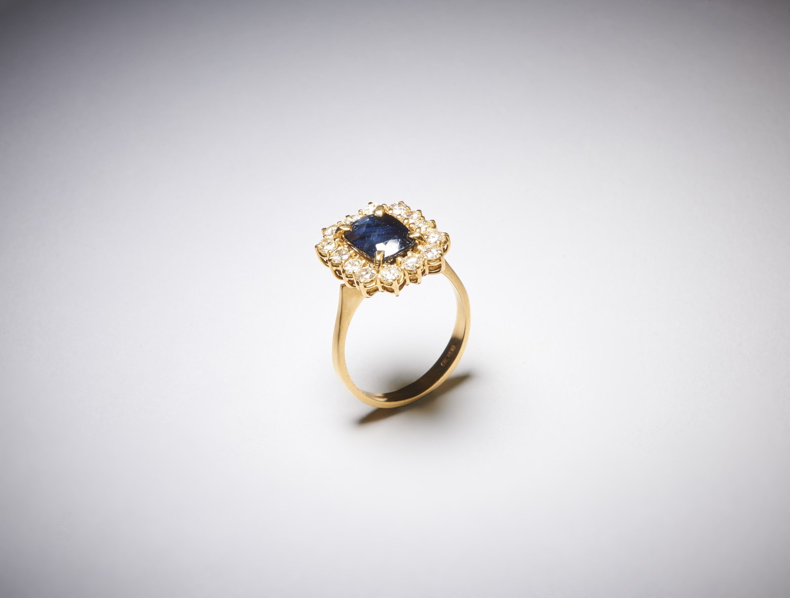 750/1000 yellow gold ring with brilliant cut round diamonds of about 1.00 carats H/I vs and central blue sapphire cushion cut of about 3.00 carats.  (. )