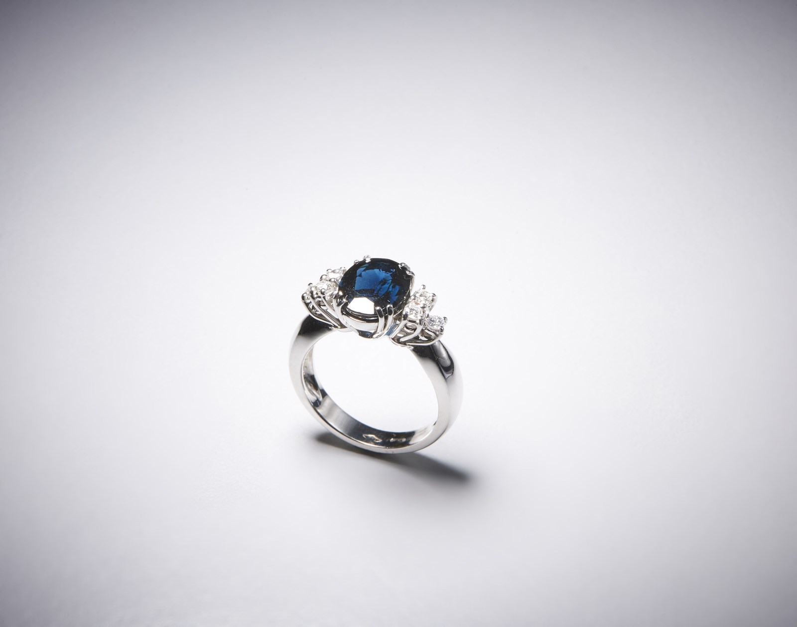 Elegante anello in oro bianco 750/1000 con zaffiro blu  taglio ovale di circa 4,00 ct. e diamanti taglio a brillante di circa 0,40 ct. (. )