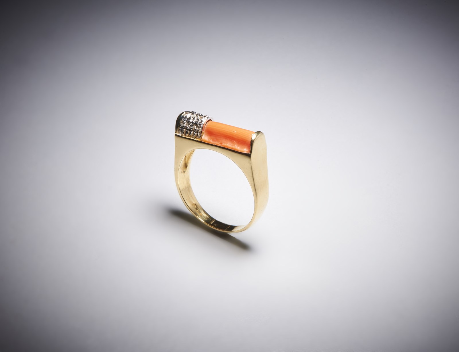 Yellow gold ring 750/1000 of geometric shape with pink coral cylinder and small pavè of white diamonds huit huit cut for 0,15 carats total approximately. (. )