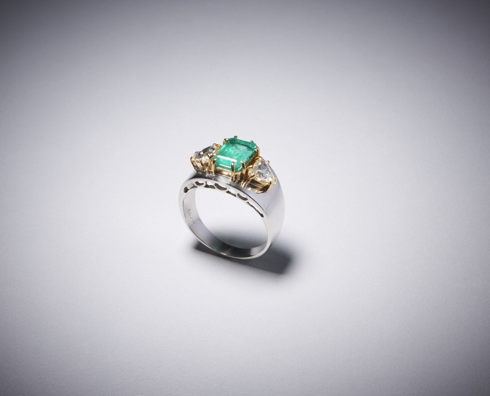 Anello in oro bianco con smeraldo e diamanti 18 kt con smeraldo centrale e due diamanti triangolari. (. )