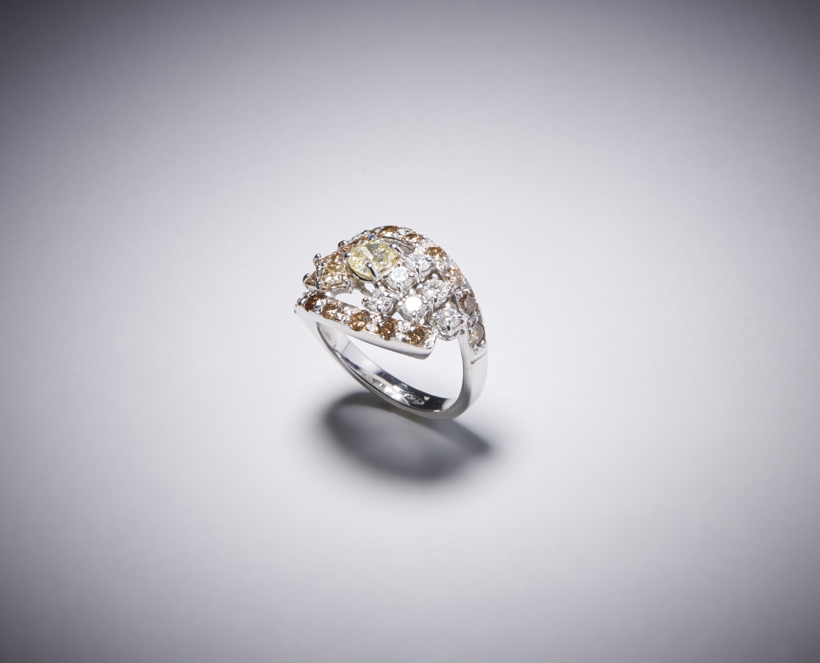 Anello in oro bianco 750/1000 con diamante fancy yellow taglio a cuscino di circa 0,50 ct.; 6 diamanti bianchi taglio a brillante per 0,45 ct. e diamanti brown taglio a brillante di circa 1,00 ct. (. )