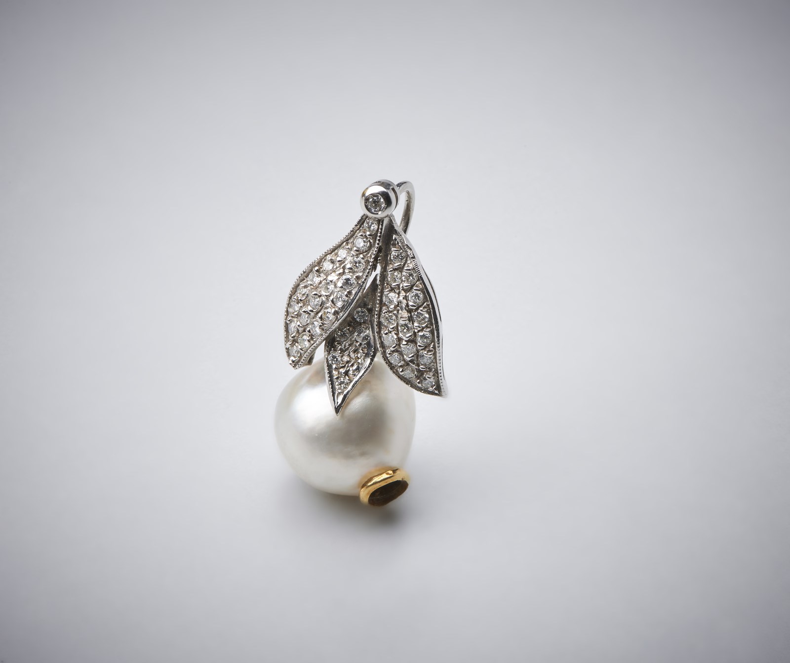 Leaf-shaped pendant with pavè of brilliant cut white diamonds of about 1.50 ct in 750/1000 white gold and 15.00 mm cultured Australian pearl. (. )