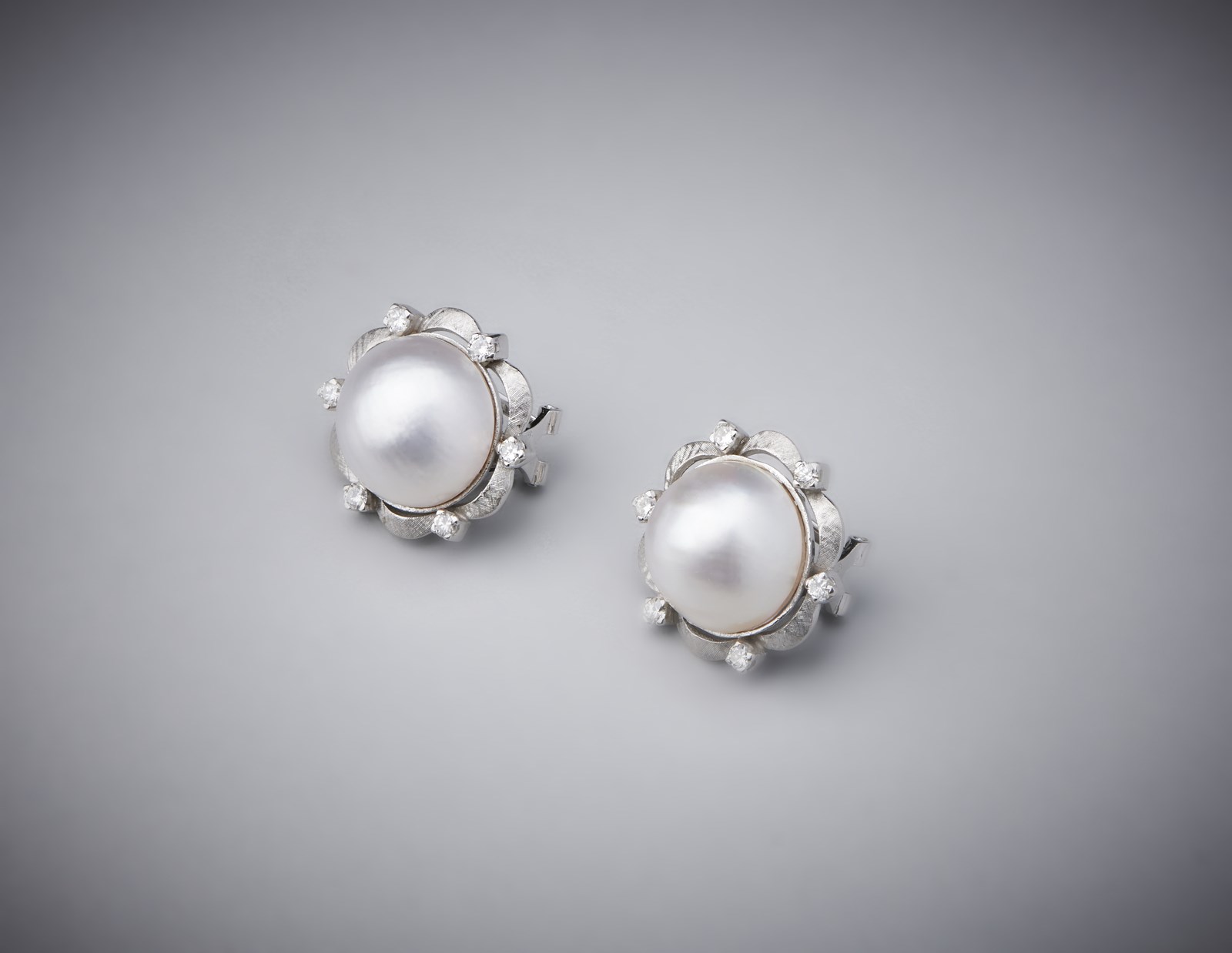 Orecchini artigianali in oro bianco 750/1000 con perle mabè e diamanti bianchi.  (. )