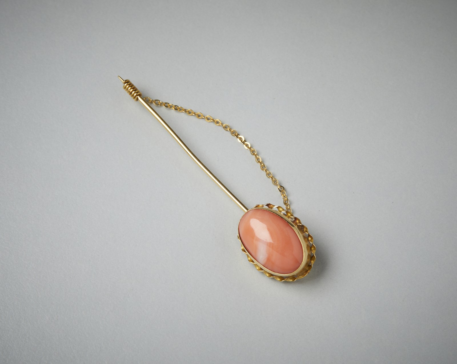 Jacket pin in yellow gold 750/1000 with pink coral cabochon. (. )