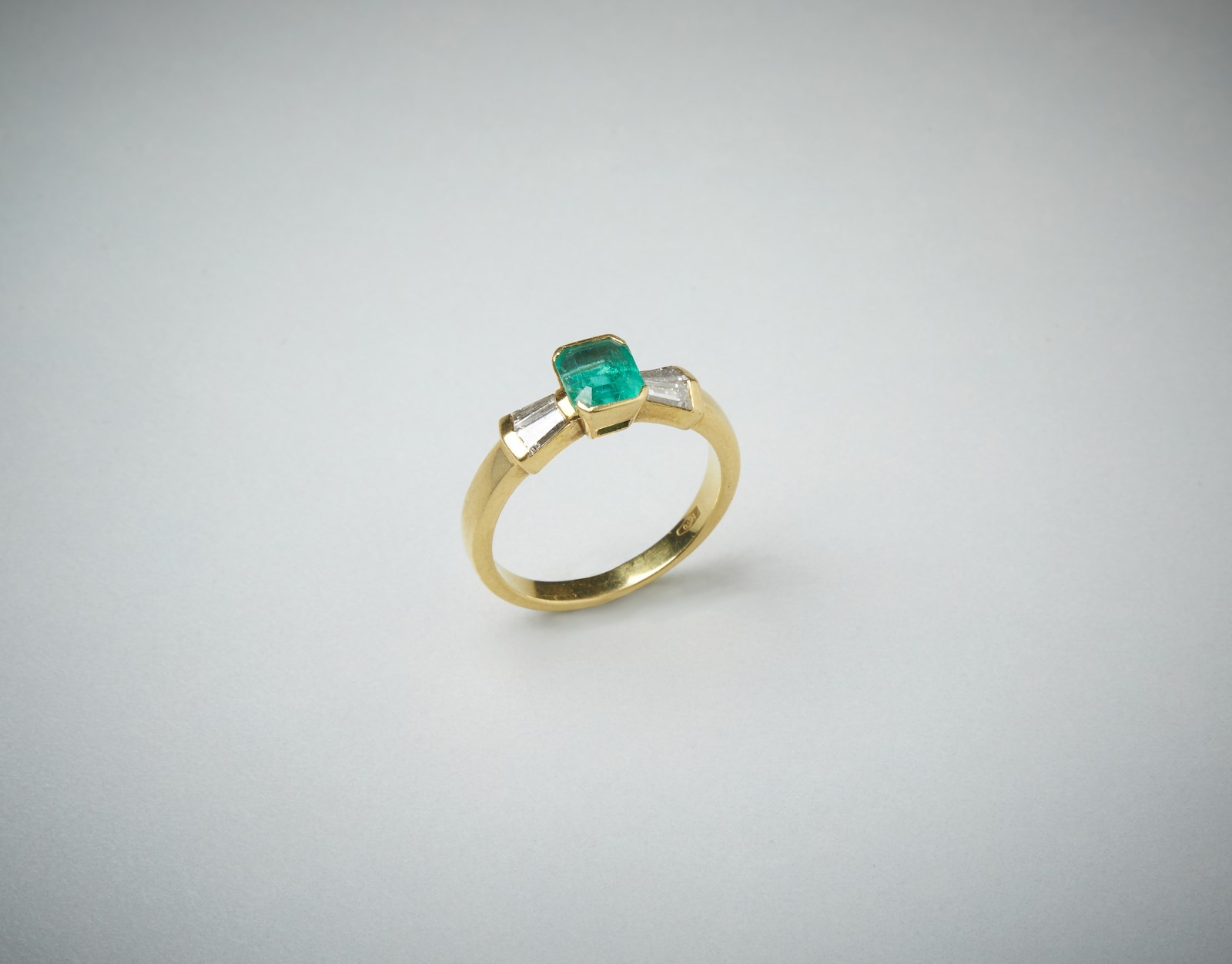 Ring in yellow gold 750/1000 with central Colombian emerald, 0.80 ct approx. and tapered diamonds, 0.40 ct approx.  (. )