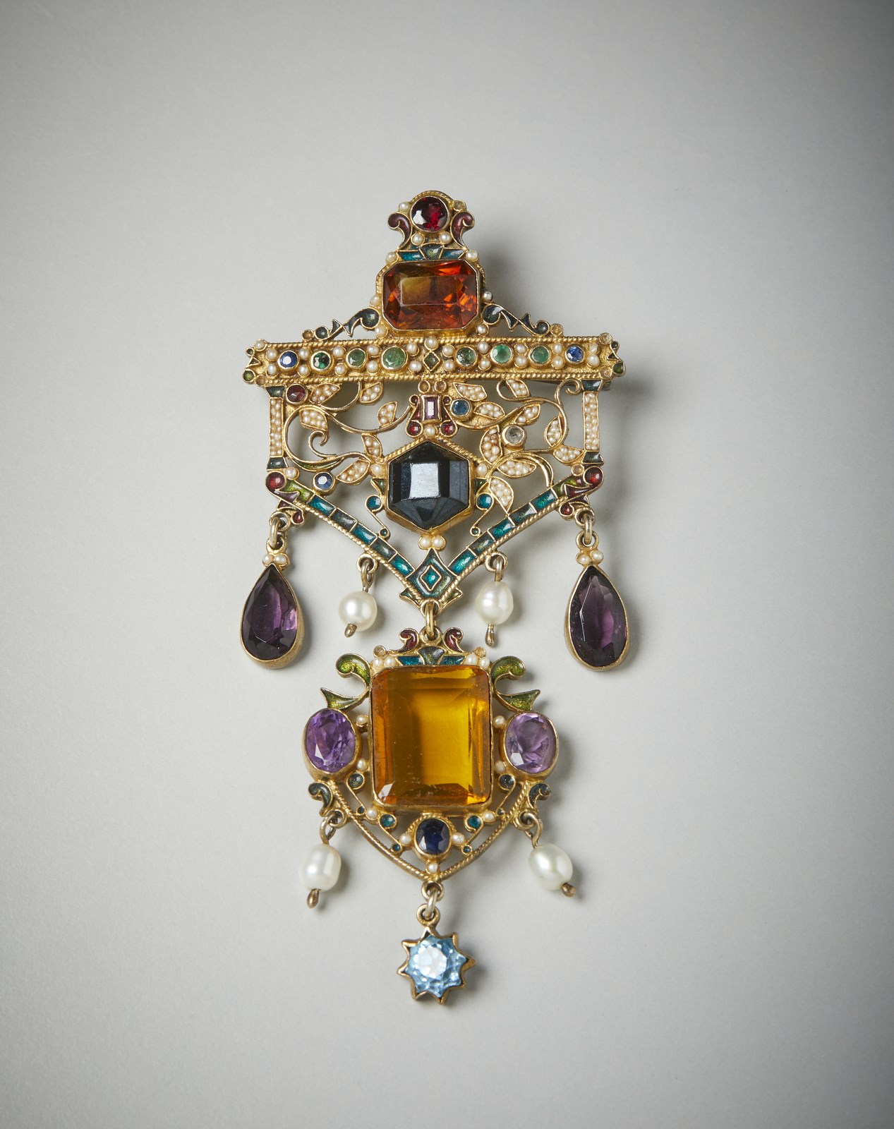 Spilla ciondolo bijoux inizio '900. 
Di pregiata manifattura in metallo dorato, perline e pietre sintentiche colorate.  (. )