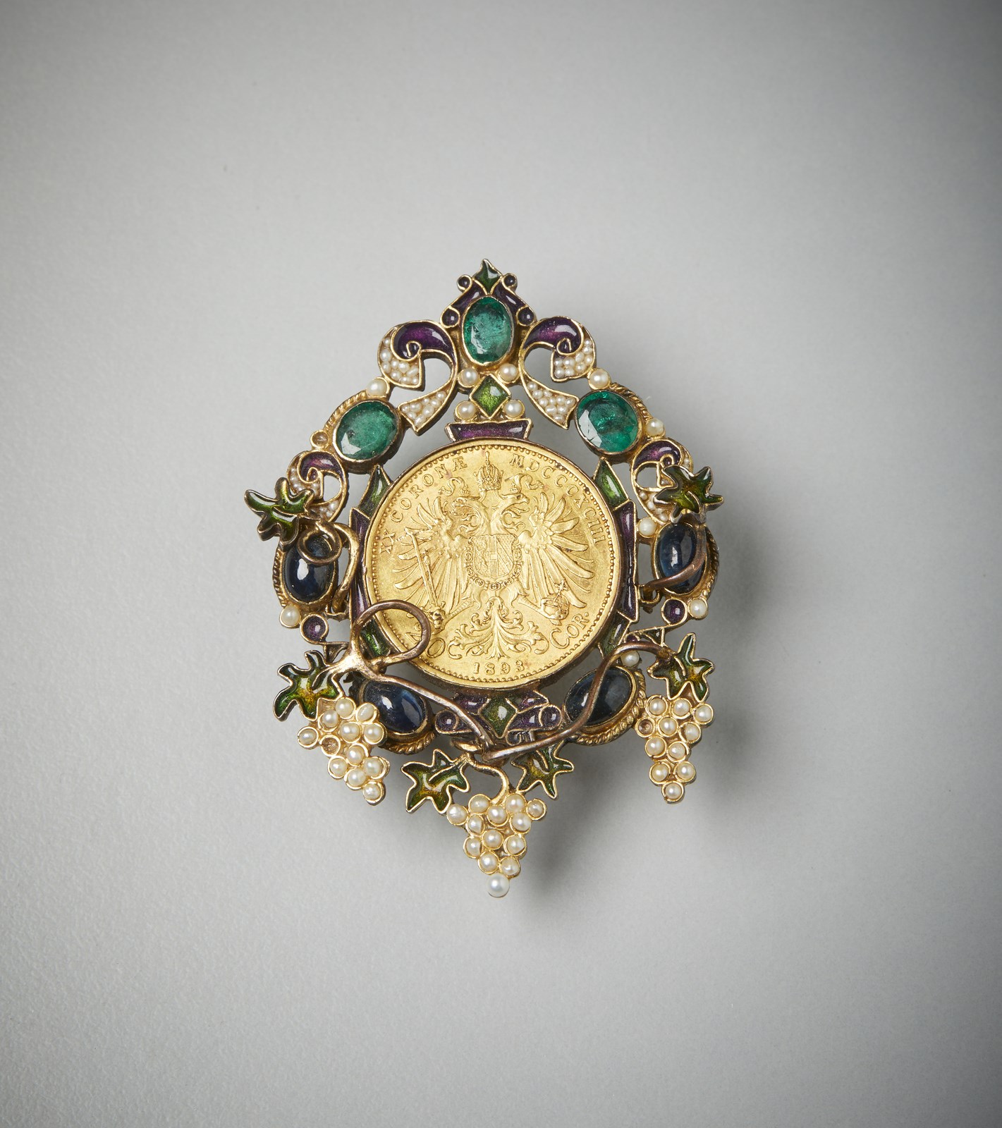 Silver brooch of fine manufacture signed Percossi Papi Roma, depicting vine shoots surrounded by three oval emeralds of about 1.5 carats total.  (. )