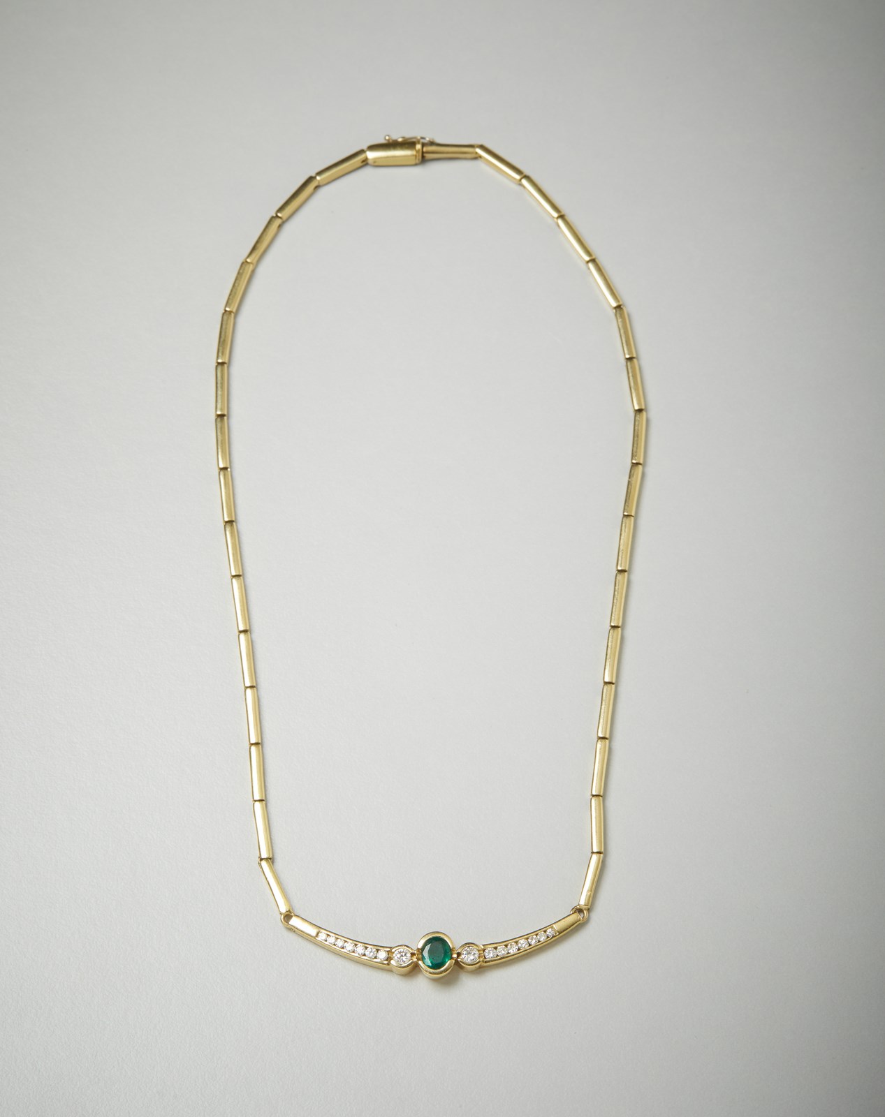 Necklace with segments in yellow gold 750/1000 with central emerald and dégradés diamantini.  (. )