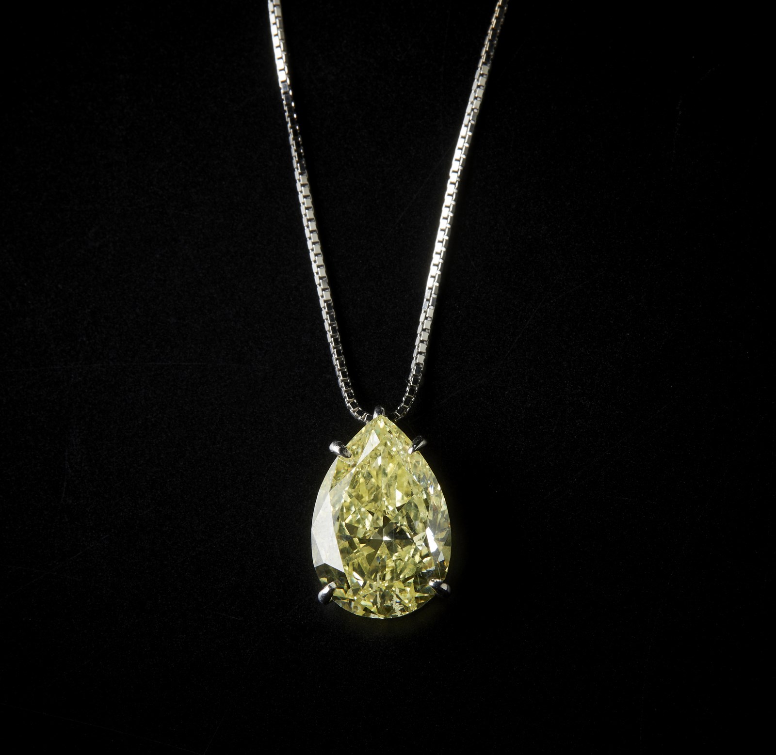 Ciondolo con catenina in oro bianco 750/1000 con importante diamante a goccia fancy yellow intense, 4,23 carati. 
 (. )