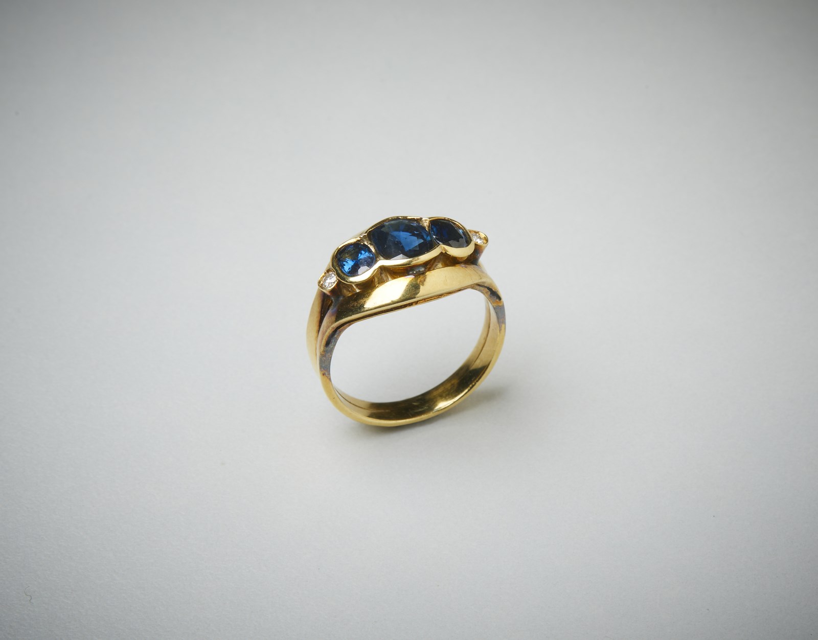 Yellow gold 750/1000 ring with three sapphires of about 2.00 ct. and two small white diamonds of 0.12 ct. total.  (. )