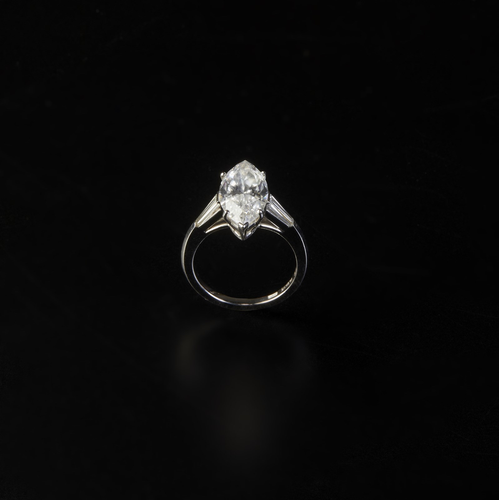 750/1000 white gold ring with marquise central cut diamond weighing 3.44 ct. flanked by two white tapered cut diamonds. 
Internal features: VVS1
Color: D (. )
