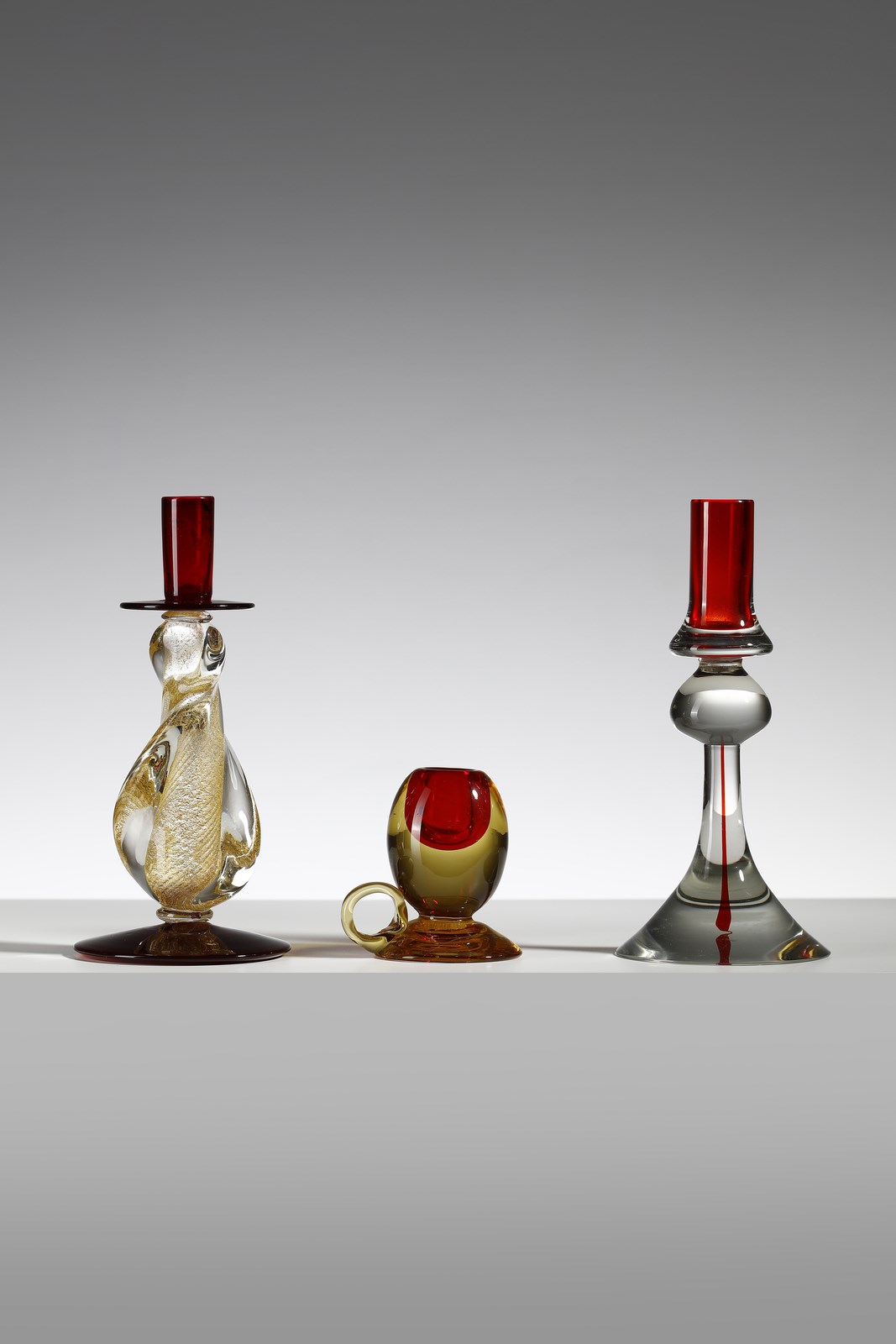 Tre candelabri in vetro trasparente sommerso, due in rosso e uno in oro, (Vetreria Cenedese )